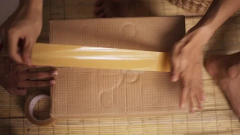 Hands Packing Items into Cardboard Box Stock Footage 344235938