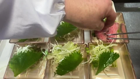 Hands Packing Roast Beef Bento Lunch Boxes with Green Leaves, Japanese Food Stock Footage 343348383