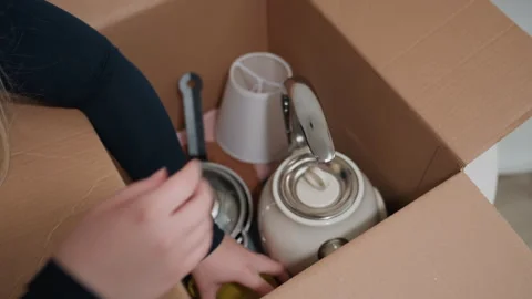Hands packing utensils. Preparing kitchenware for move with attention to detail Stock Footage 342055415