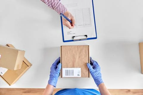 Hands with parcel box and customer signing papers Stock Photos