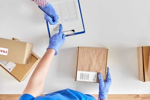 Hands with parcel box and customer signing papers 库存照片