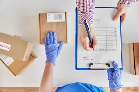 Hands with parcel box and customer signing papers 写真素材