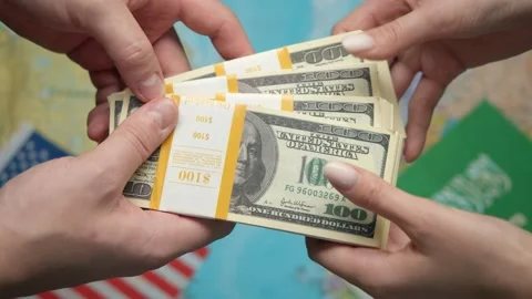 Hands pass stack of US dollars to Saudi Arabia representative against world map Stock Footage 331263347