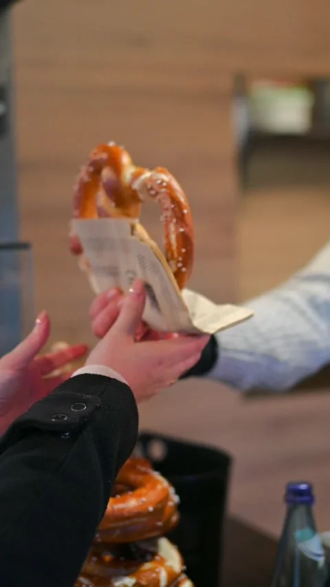 Hands Passing a Hot Pretzel at a Christmas Market Stock Footage 316968610