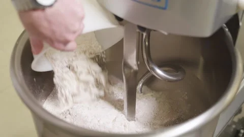 Hands of Pastry Chef put in white flour in Dough Kneading Machine, adding Stock Footage 162796861