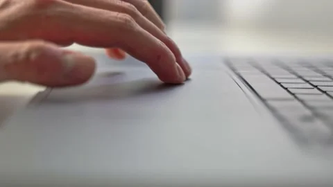 Hands patiently use the computer laptop touchpad to guide a gaming Stock Footage 213792240