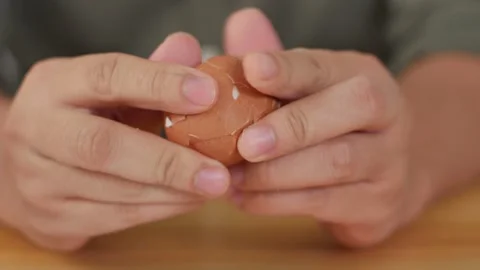 Hands peel eggshells from boiled egg. Opening hard boiled egg, protein source Stock Footage 141574124