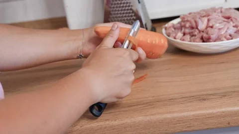 Hands peel fresh carrots in the kitchen Stock Footage 318463563