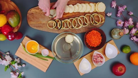 Hands peeling and cutting ingredients on wooden boards in kitchen Stock Footage 342935173