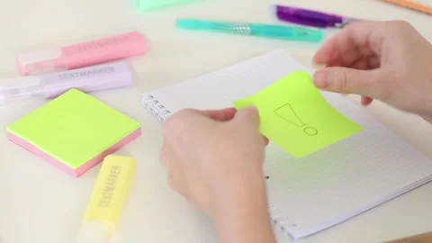 Hands peeling and sticking warning note onto blank page on white desk Stock Footage 331801616