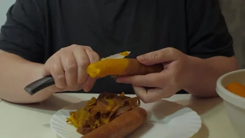 Hands peeling boiled carrot with small knife Vidéo 342362187