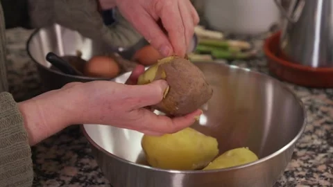 Hands peeling a boiled potato in the kitchen Stock-Footage 331218544