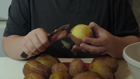 Hands peeling boiled potatoes with knife Vidéo 342362203