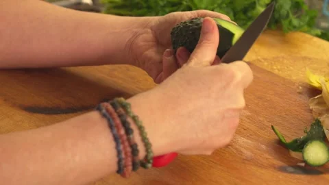 Hands peeling fresh cucumber on board Stock-Footage 331313998
