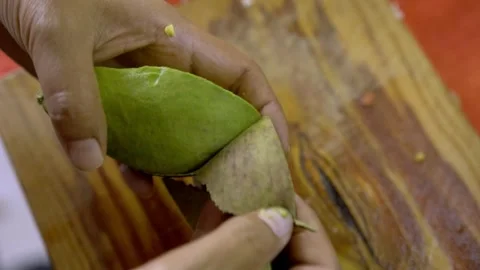 Hands Peeling Fresh Green Mango On Wooden Cutting Board Vidéo 333451744