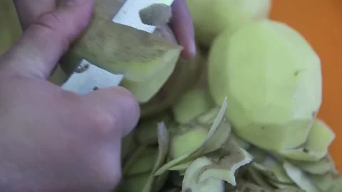 Hands peeling a large potato with a knife, for cooking fried potatoes Vídeos de archivo 223347265