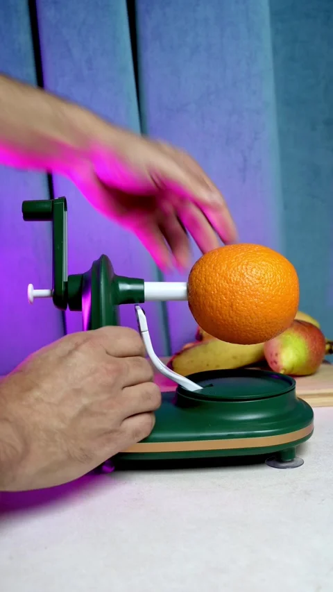 Hands Peeling Orange With Mechanical Rotary Peeler 库存影片 345219346