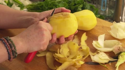 Hands peeling raw potatoes on a cutting board Stock-Footage 331313986