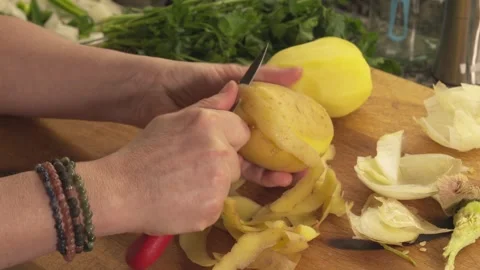 Hands peeling raw potatoes with knife Stock Footage 331313979