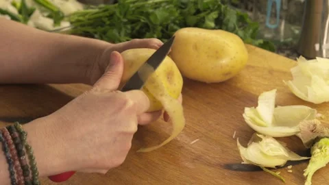 Hands peeling a raw yellow potato with a knife 스톡 동영상 331313973