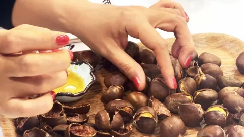 Hands peeling a small chestnut Stock Footage 262646203