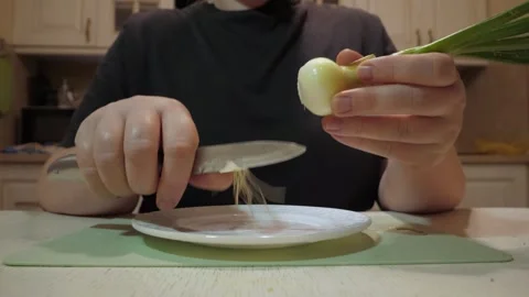 Hands peeling small onion with knife over plate Stock-Footage 342362894