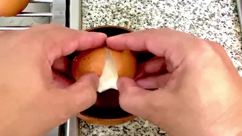 Hands Peeling a Soft Boiled Onsen Egg into a Bowl Stock Footage 342389786