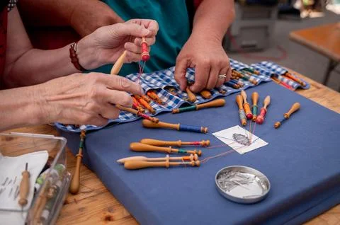 Hands of people preparing and making bobbin lace. Colorful lace threads. Stock Photos