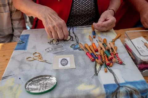 Hands of people preparing and making bobbin lace. Colorful lace threads. Stock Photos