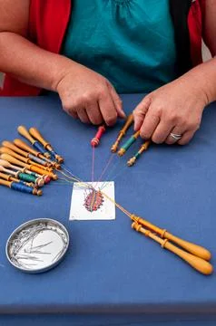 Hands of people preparing and making bobbin lace. Colorful lace threads. Stock Photos