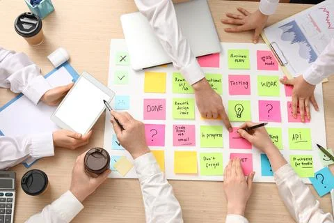 Hands of people with sticky notes working on business plan at table, top view Stock Photos