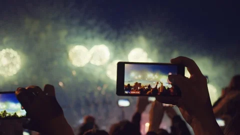 Hands of peoples taking photo to fireworks on smartphone. Close-up. Slow motion Stock Footage