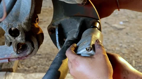 Hands performing maintenance on a truck's mechanical components in a workshop Stock Footage 340583057