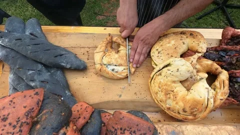 Hands of person cut fresh crispy delicious bread on wooden board in restaurant. Stock Footage 199035128