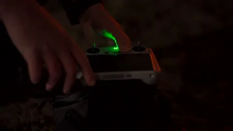 The hands of a person discreetly setting up a drone controller at night Stock Footage 233680534