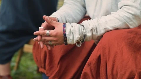 Hands of a person dressed in simple medieval clothing are seen working on 库存影片 345033168