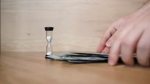 The hands of person pick up a stack of American 100 dollars. Time is money Stock Footage 151971820