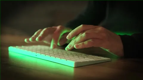 Hands of person typing on mobile computer closeup in neon room. Stock Footage 246002218