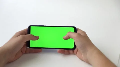 In the hands of a phone with a green screen on a light background Video stock 223403330