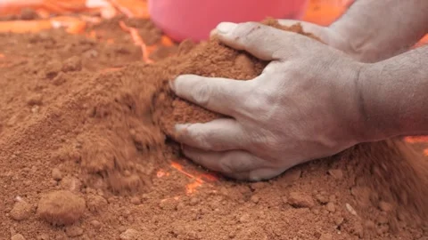 Hands picjing a hand full of red construction sand Stock Footage 241841435
