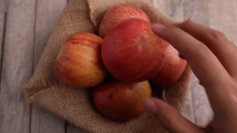 Hands pick up apples one by one on the table 库存影片 275872370