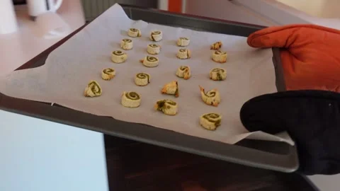 Hands pick up the baking tray with cinnamon rolls Stock Footage 296488101