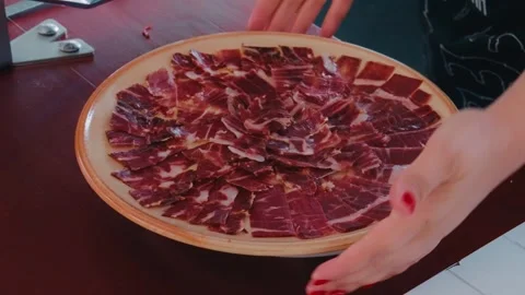 Hands Pick Up Plate of Sliced Jamón Ibérico Spanish Ham Stock Footage 346022995