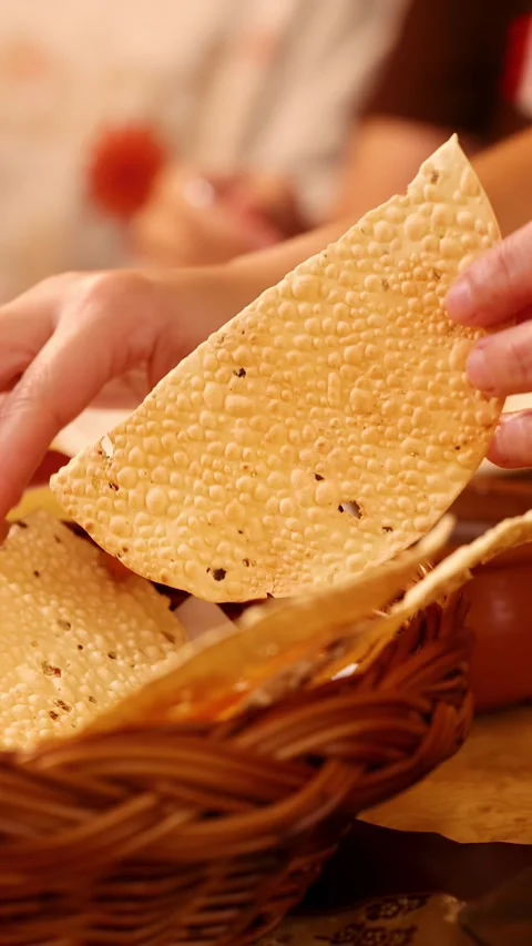 Hands Picking and Breaking Crispy Papadum From a Woven Basket Stock Footage 339513902