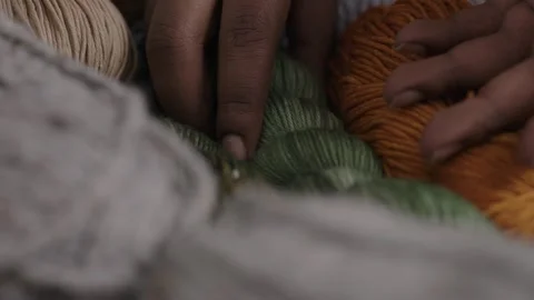 Hands Picking Up and Setting Down Colorful Yarn Skeins, Close-Up Stock-Footage 323945569