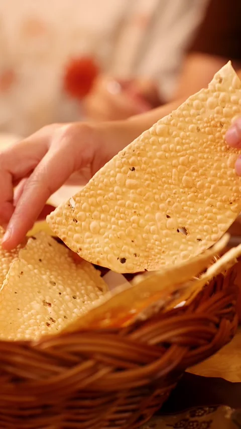 Hands Picking Crispy Papadum Bread from Wicker Basket at Restaurant Stock Footage 339513484