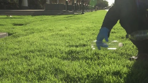 Hands picking up empty bottles to recycle from grass-01 Stock-Footage 264008040