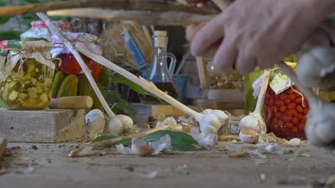 Hands picking garlic from the table. Pickled farm vegetables in glass jars Stock Footage 248706503