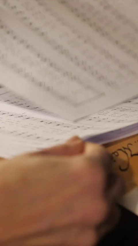 Hands picking up music sheets, closeup of choir singers taking papers with 動画素材 332728524