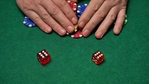 Hands picking up poker chips on a green felt table, showing a gambling scene Stock Footage 327594852